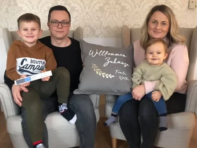 Familie mit Kindern auf dem Sofa im neuen Zuhause
